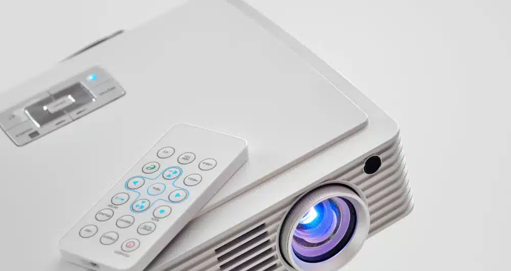 Modern white projector with a remote control, designed for home entertainment systems to be used as TV.