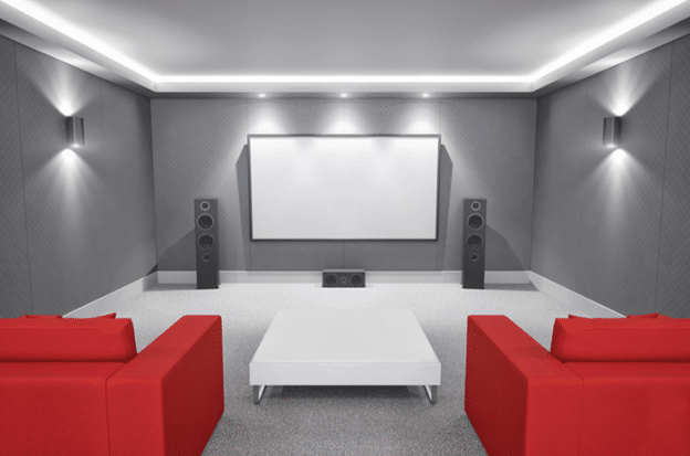Modern home cinema setup featuring a large projector screen, surround sound speakers, red seating, and ambient lighting for a cinematic experience.